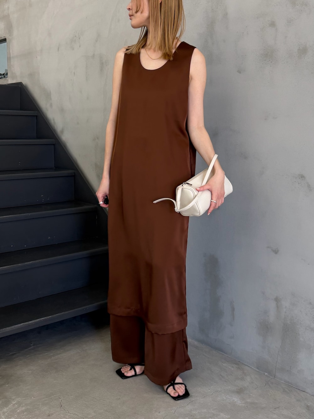 ホワイト系のハンドバッグ、ブラック系のサンダル、ホワイト系のキャミソールを着用したレディースの春コーディネートの7枚目の写真