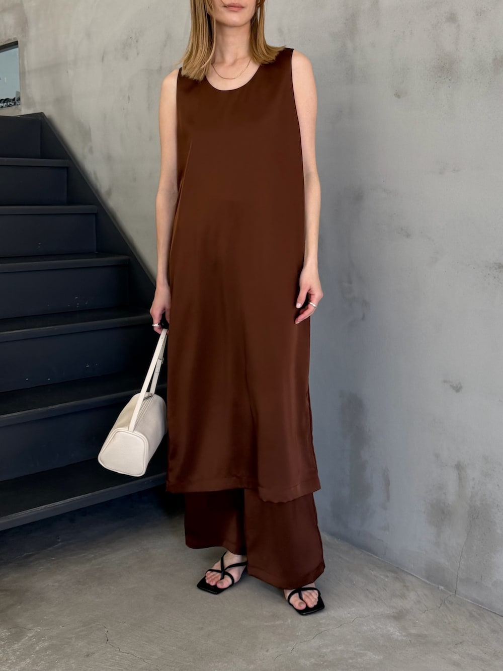 ホワイト系のハンドバッグ、ブラック系のサンダル、ホワイト系のキャミソールを着用したレディースの春コーディネートの8枚目の写真