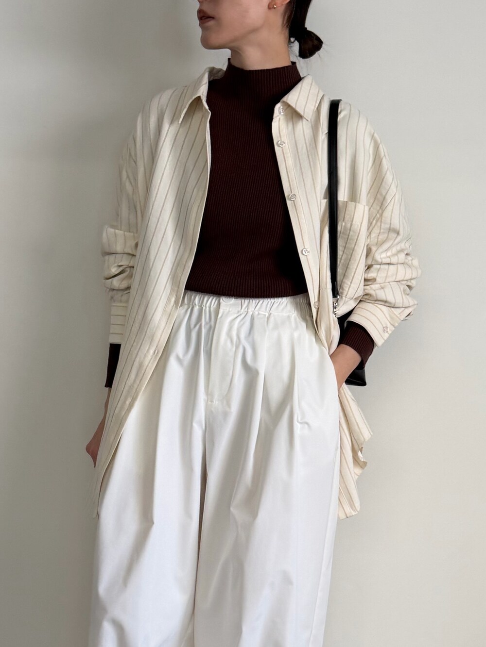 ブラウン系のニット/セーター、ホワイト系のその他パンツ、ブラック系のスリッポンを着用したレディースの冬コーディネートの6枚目の写真