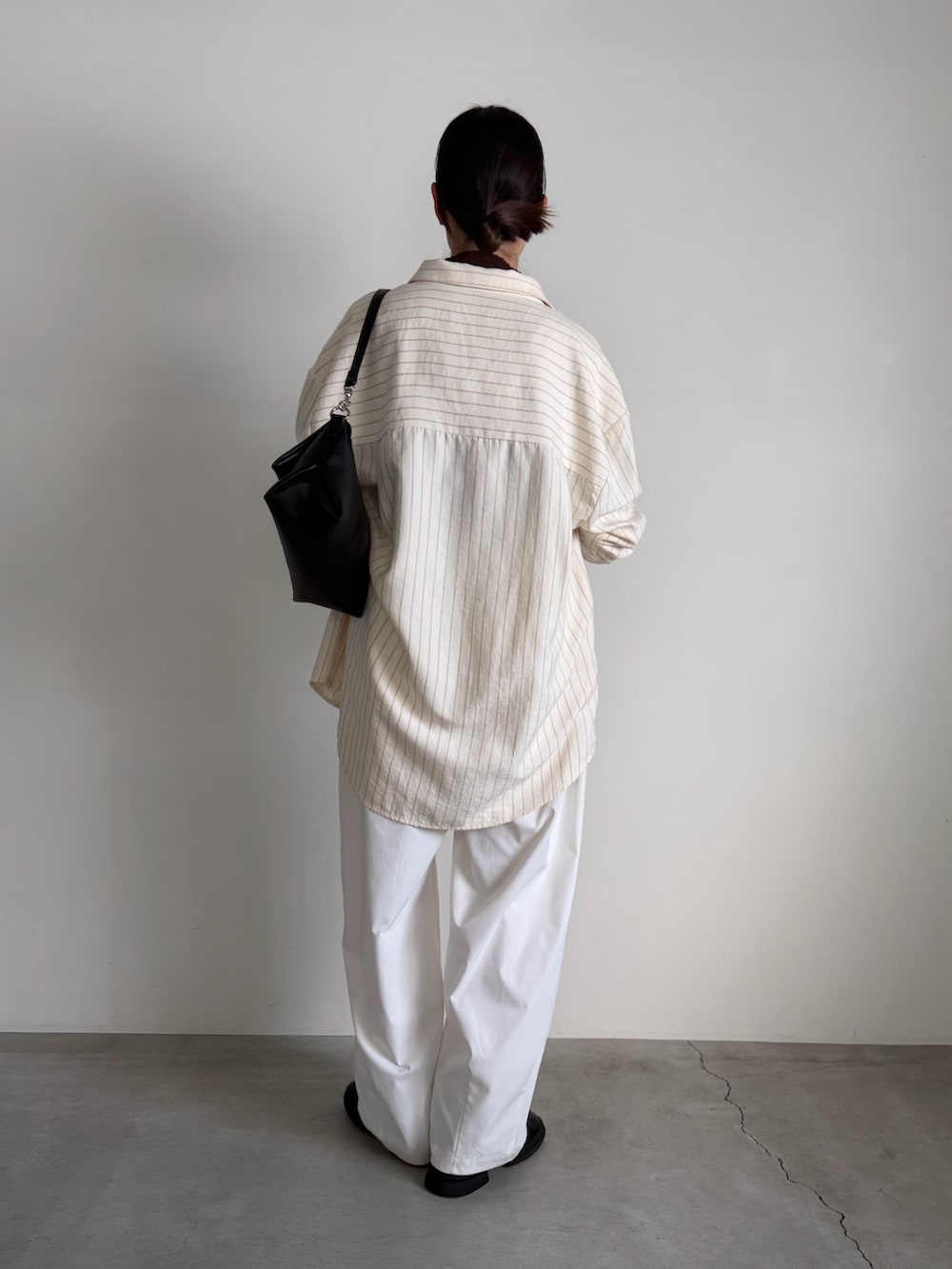 ブラウン系のニット/セーター、ホワイト系のその他パンツ、ブラック系のスリッポンを着用したレディースの冬コーディネートの4枚目の写真