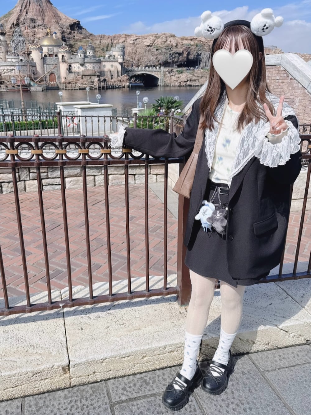 ブラック系のテーラードジャケット、ブラック系のスカート、ホワイト系のTシャツ/カットソーを着用したレディースの秋コーディネートの2枚目の写真