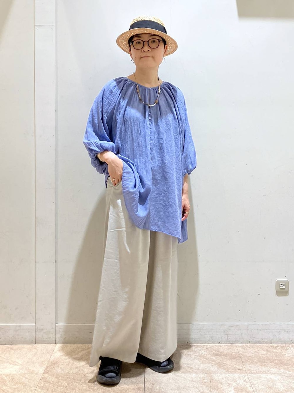 グレー系のその他パンツ、ブルー系のチュニック、シルバー系のイヤーカフを着用したレディースの夏コーディネートの5枚目の写真