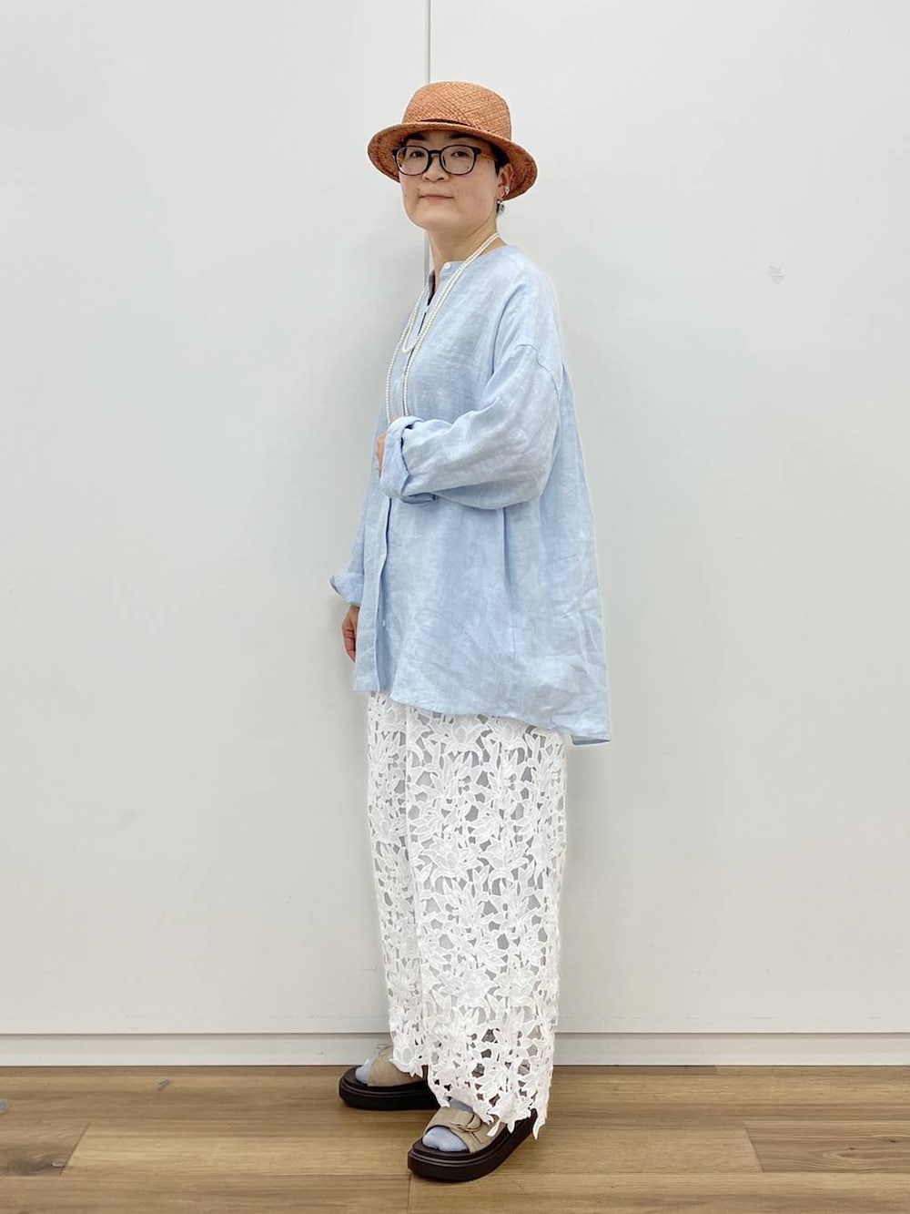 ブラック系のタンクトップ、ベージュ系のサンダル、ホワイト系のネックレスを着用したレディースの春コーディネートの3枚目の写真