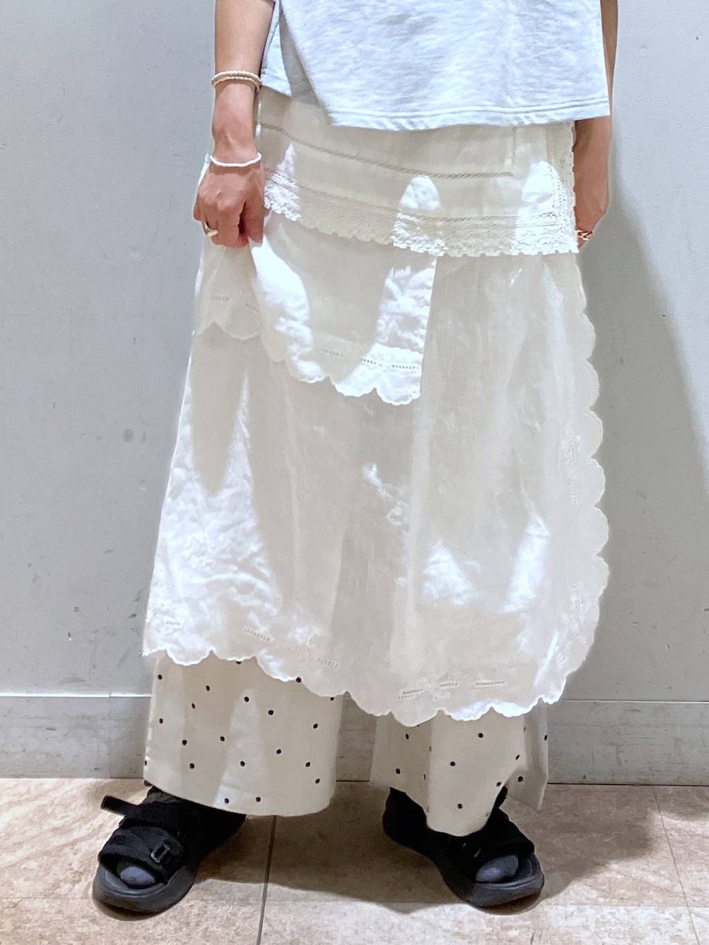 ホワイト系のスカート、グレー系のTシャツ/カットソー、シルバー系のイヤーカフを着用したレディースの春コーディネートの8枚目の写真