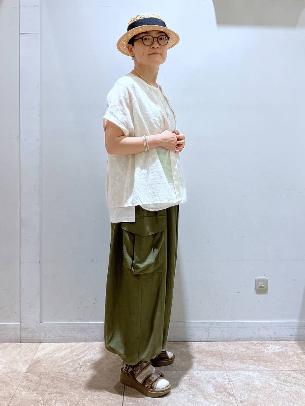グリーン系のカーゴパンツ、その他のサンダル、ベージュ系のTシャツ/カットソーを着用したレディースの夏コーディネートの3枚目の写真