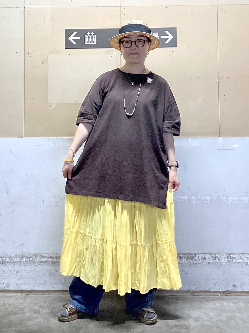 その他のサンダル、ブラウン系のTシャツ/カットソー、ブルー系のデニムパンツを着用したレディースの夏コーディネートの2枚目の写真