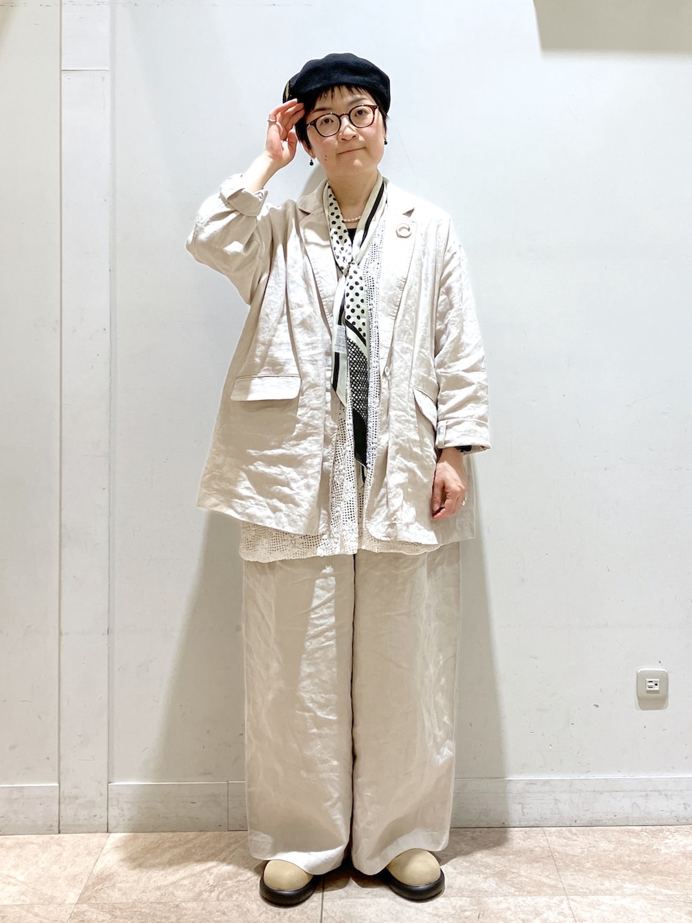 ベージュ系のスーツセット、ベージュ系のサンダル、ブラック系のタンクトップを着用したレディースの冬コーディネートの4枚目の写真