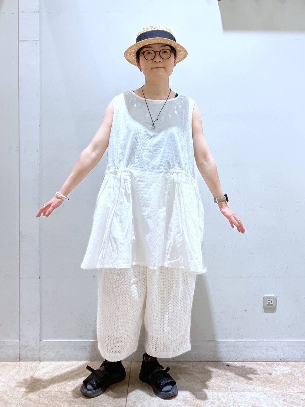 ブラック系のタンクトップ、ホワイト系のその他パンツ、その他のイヤリングを着用したレディースの春コーディネートの8枚目の写真