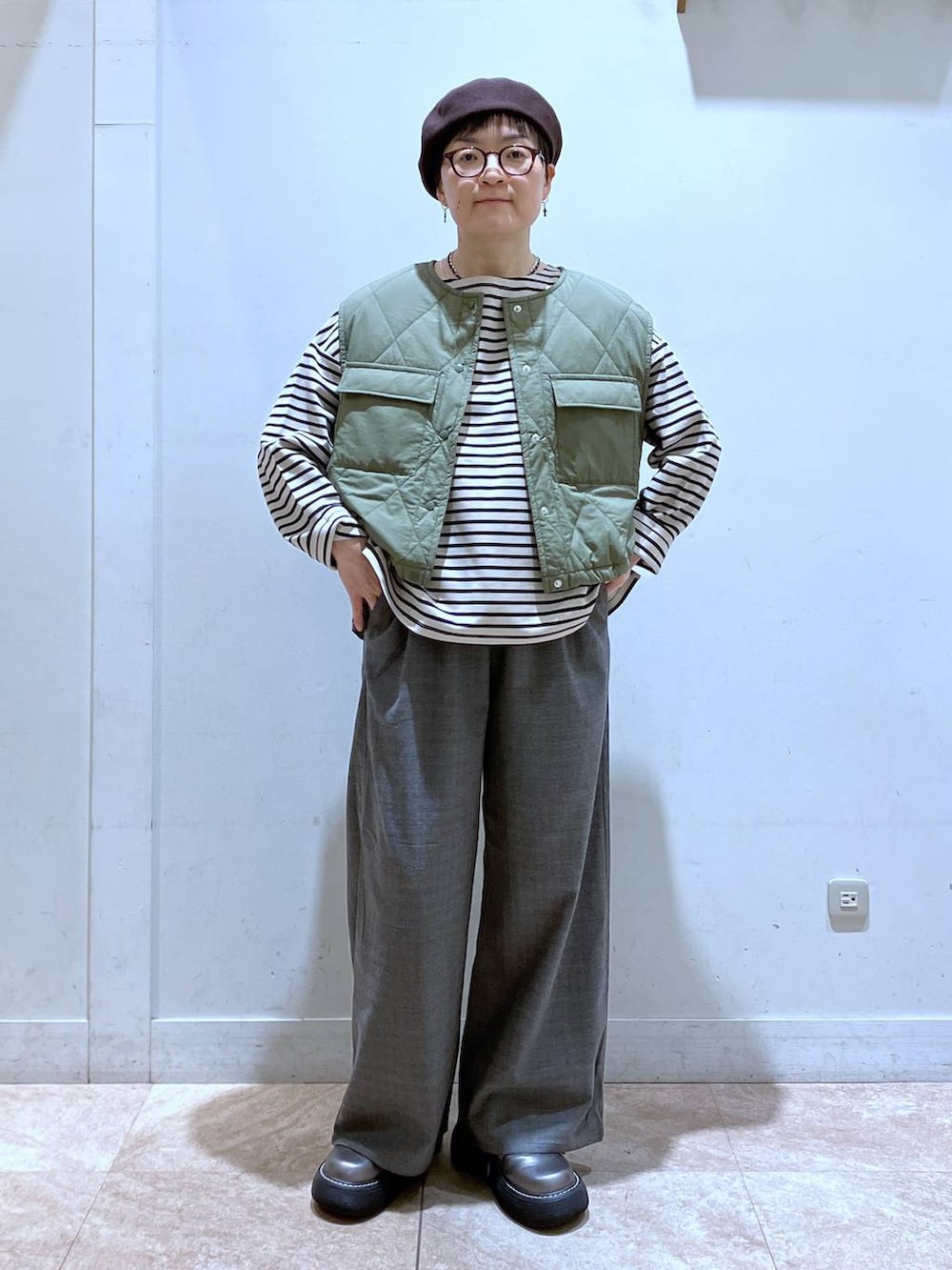 グリーン系のベスト、その他のその他シューズ、その他のTシャツ/カットソーを着用したレディースの秋コーディネートの5枚目の写真