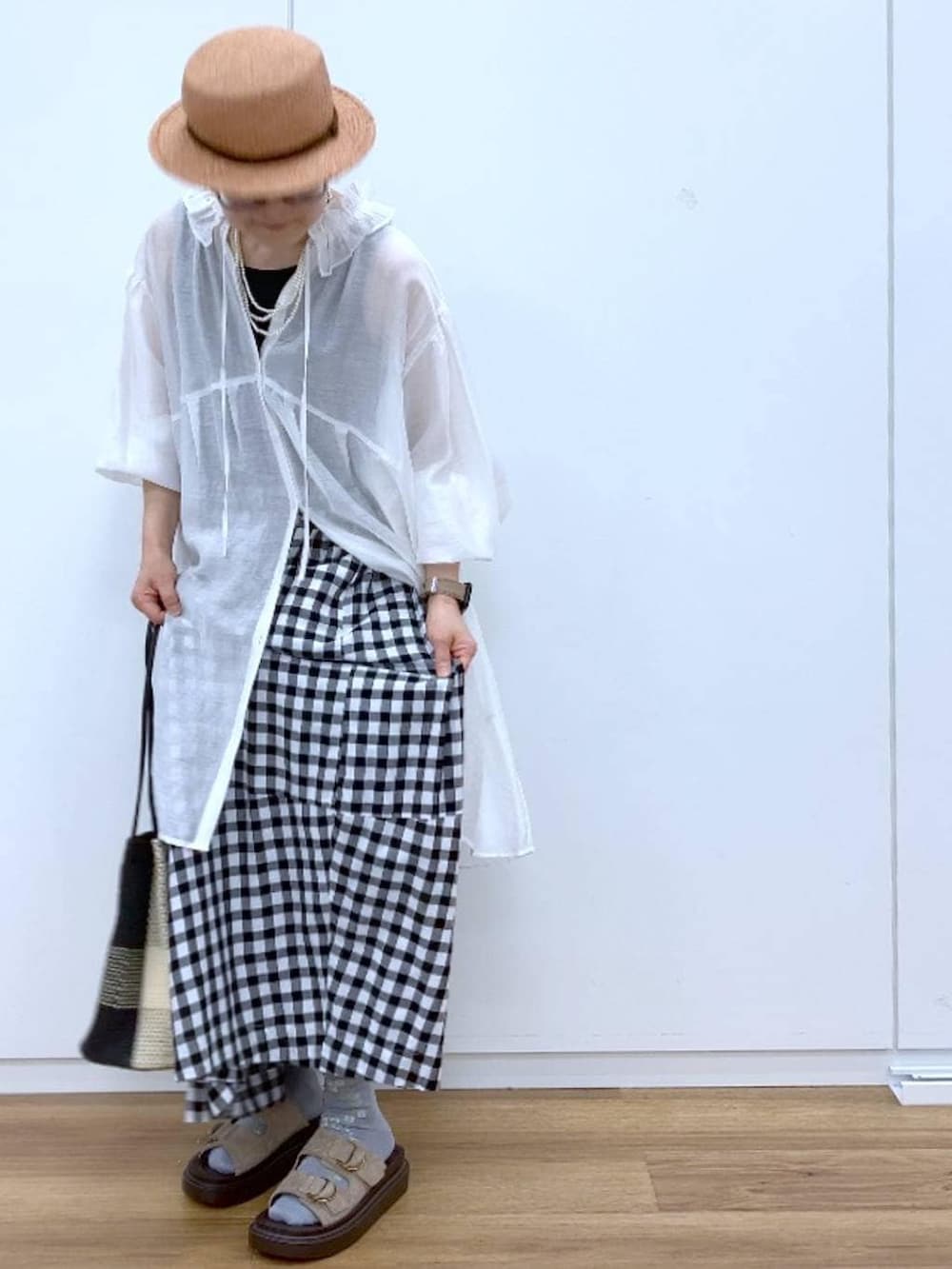 ブラック系のタンクトップ、ベージュ系のサンダル、その他のスカートを着用したレディースの春コーディネートの8枚目の写真