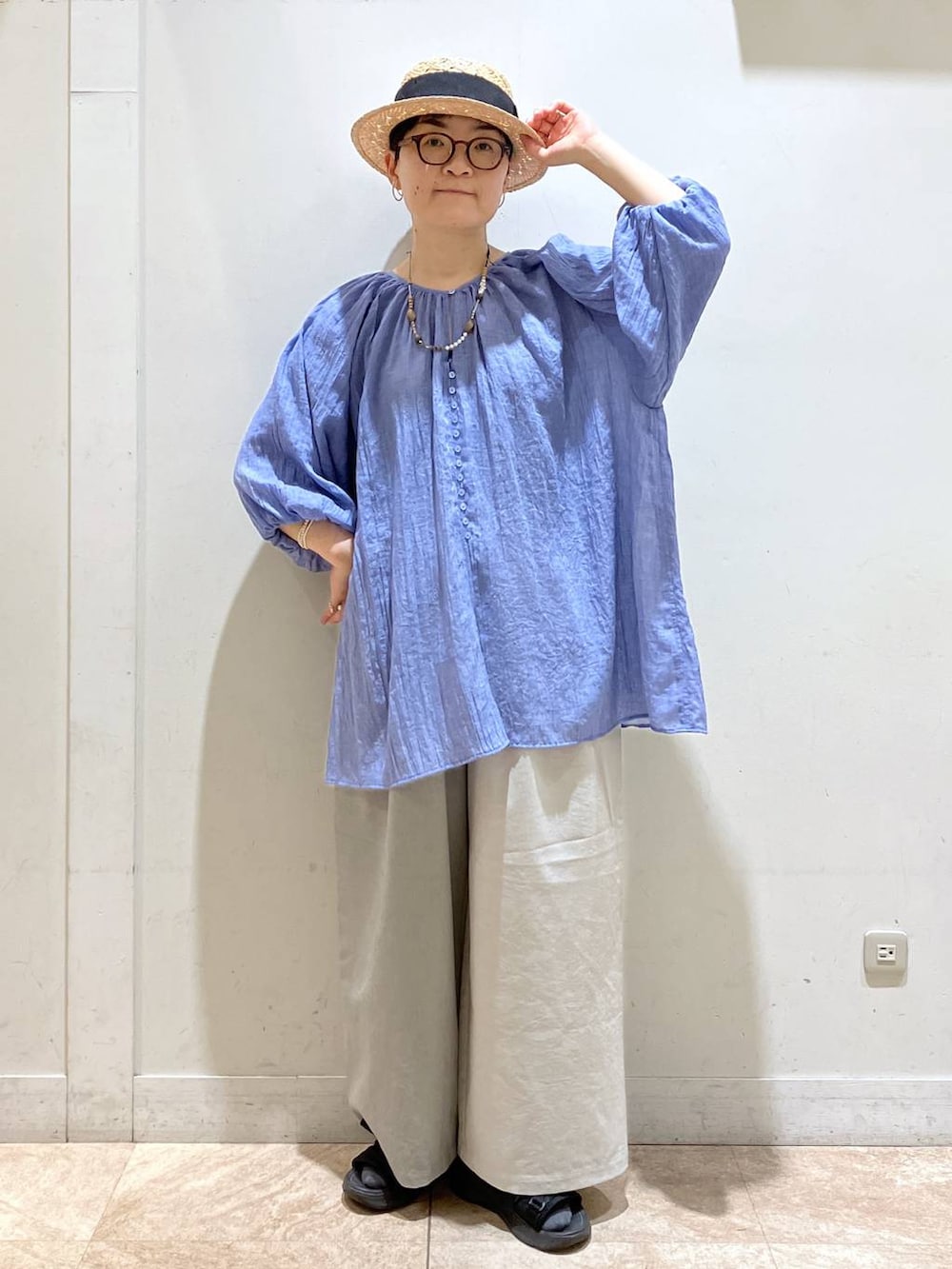 グレー系のその他パンツ、ブルー系のチュニック、シルバー系のイヤーカフを着用したレディースの夏コーディネートの2枚目の写真