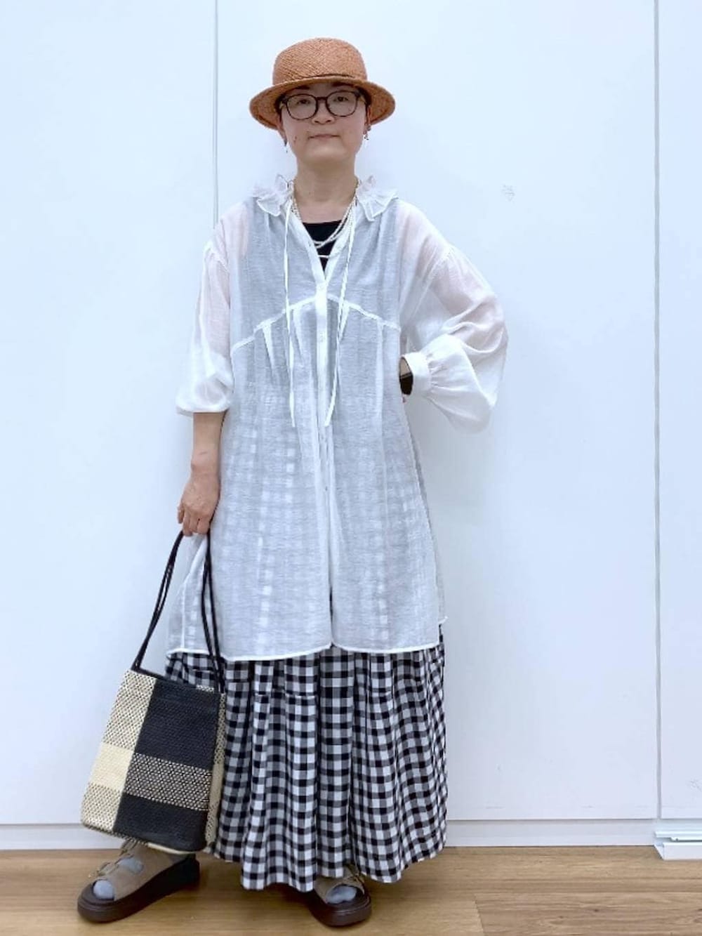 ブラック系のタンクトップ、ベージュ系のサンダル、その他のスカートを着用したレディースの春コーディネートの2枚目の写真