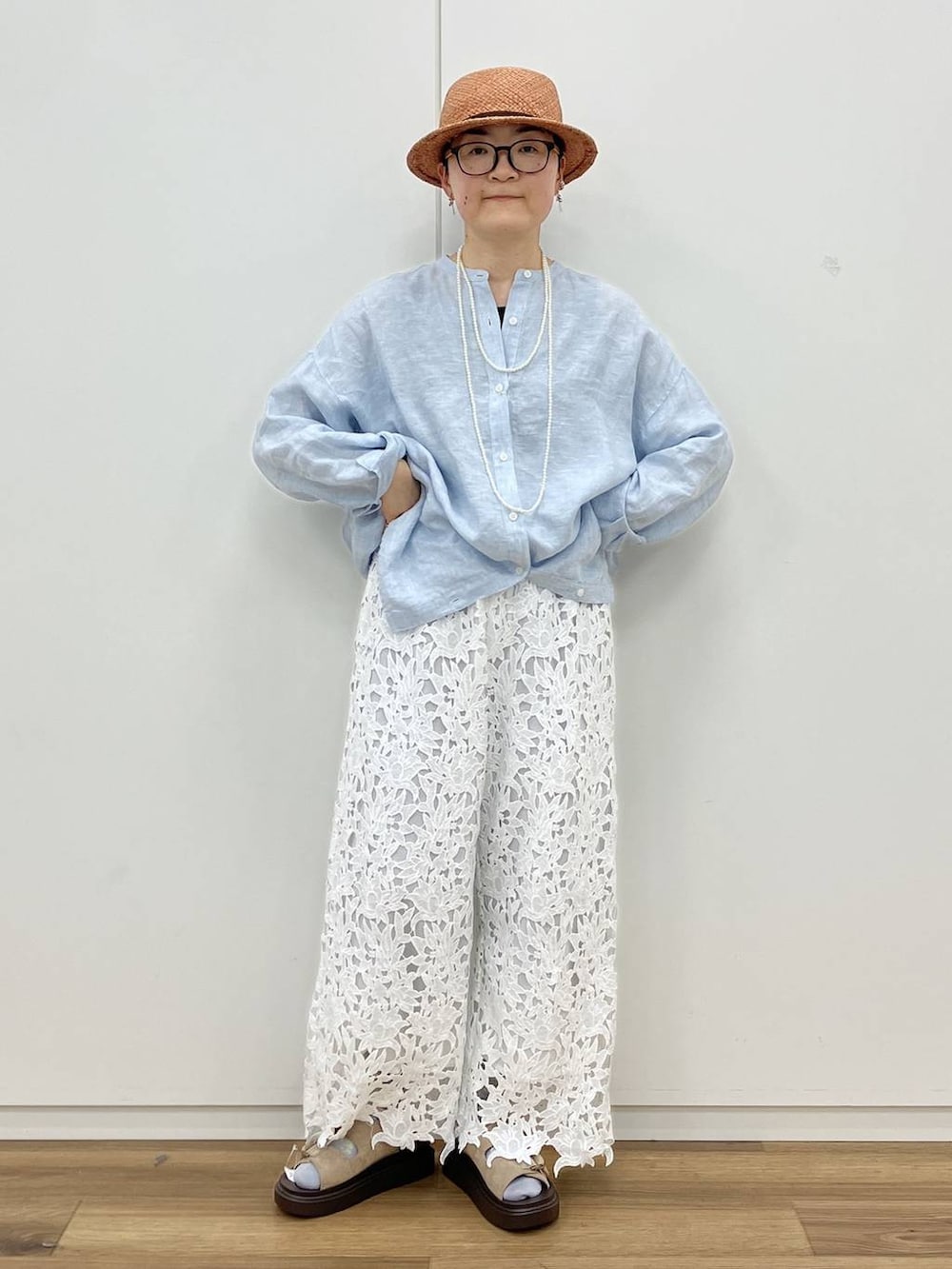 ブラック系のタンクトップ、ベージュ系のサンダル、ホワイト系のネックレスを着用したレディースの春コーディネートの2枚目の写真