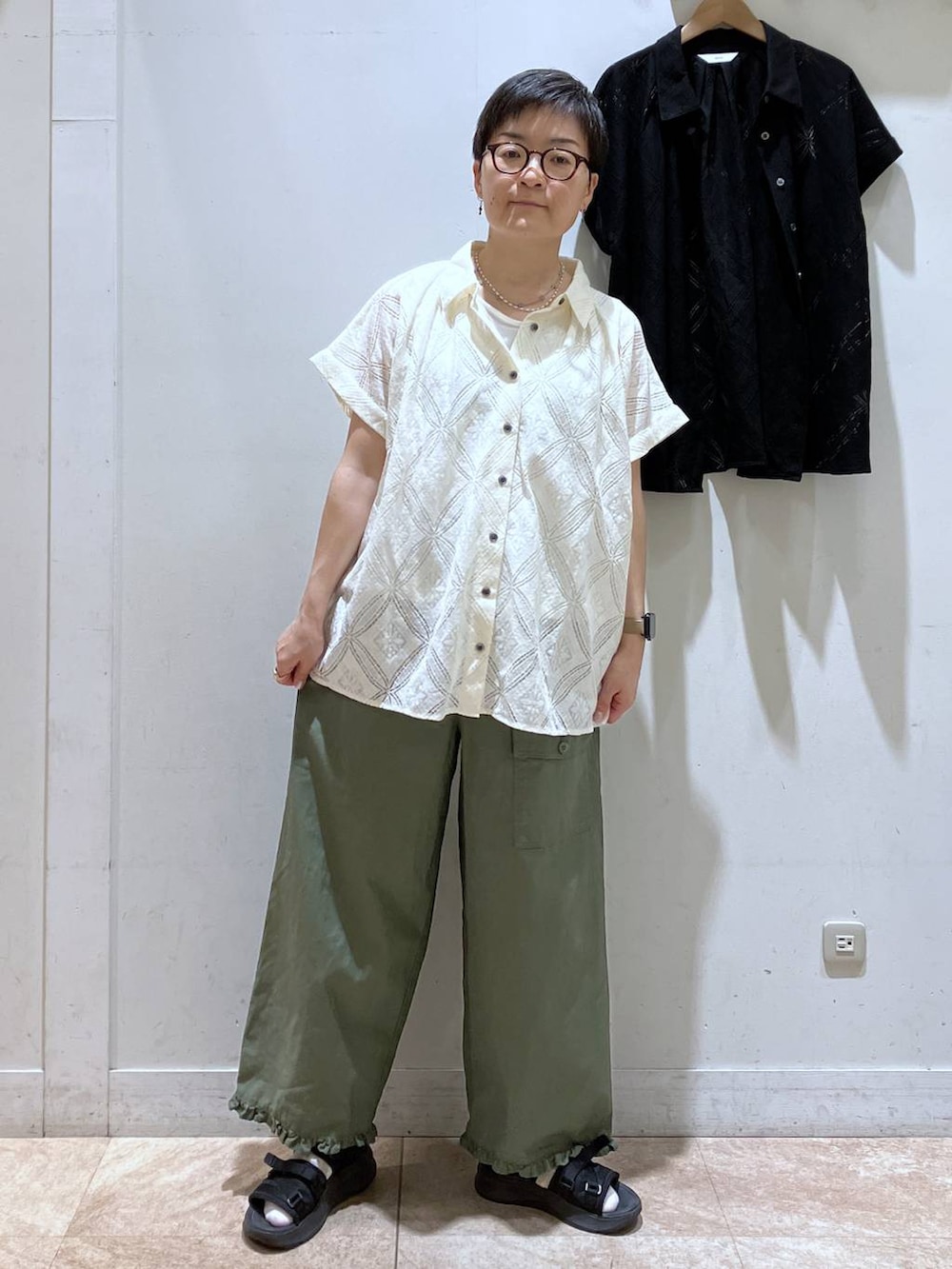 ベージュ系のシャツ/ブラウス、グリーン系のその他パンツ、ホワイト系のTシャツ/カットソーを着用したレディースの夏コーディネートの3枚目の写真