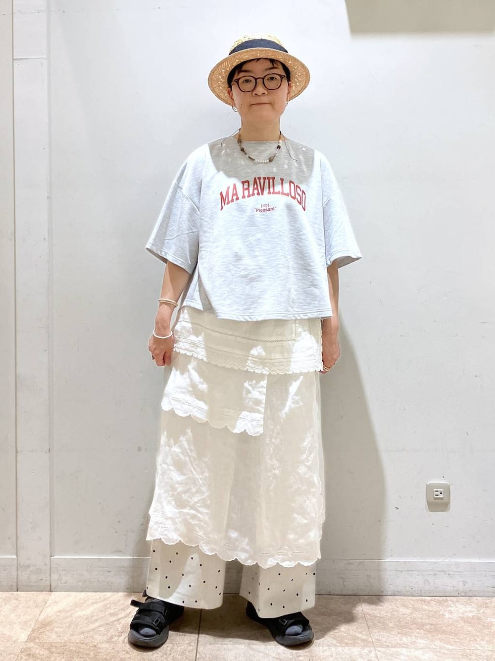 ホワイト系のスカート、グレー系のTシャツ/カットソー、シルバー系のイヤーカフを着用したレディースの春コーディネートの2枚目の写真