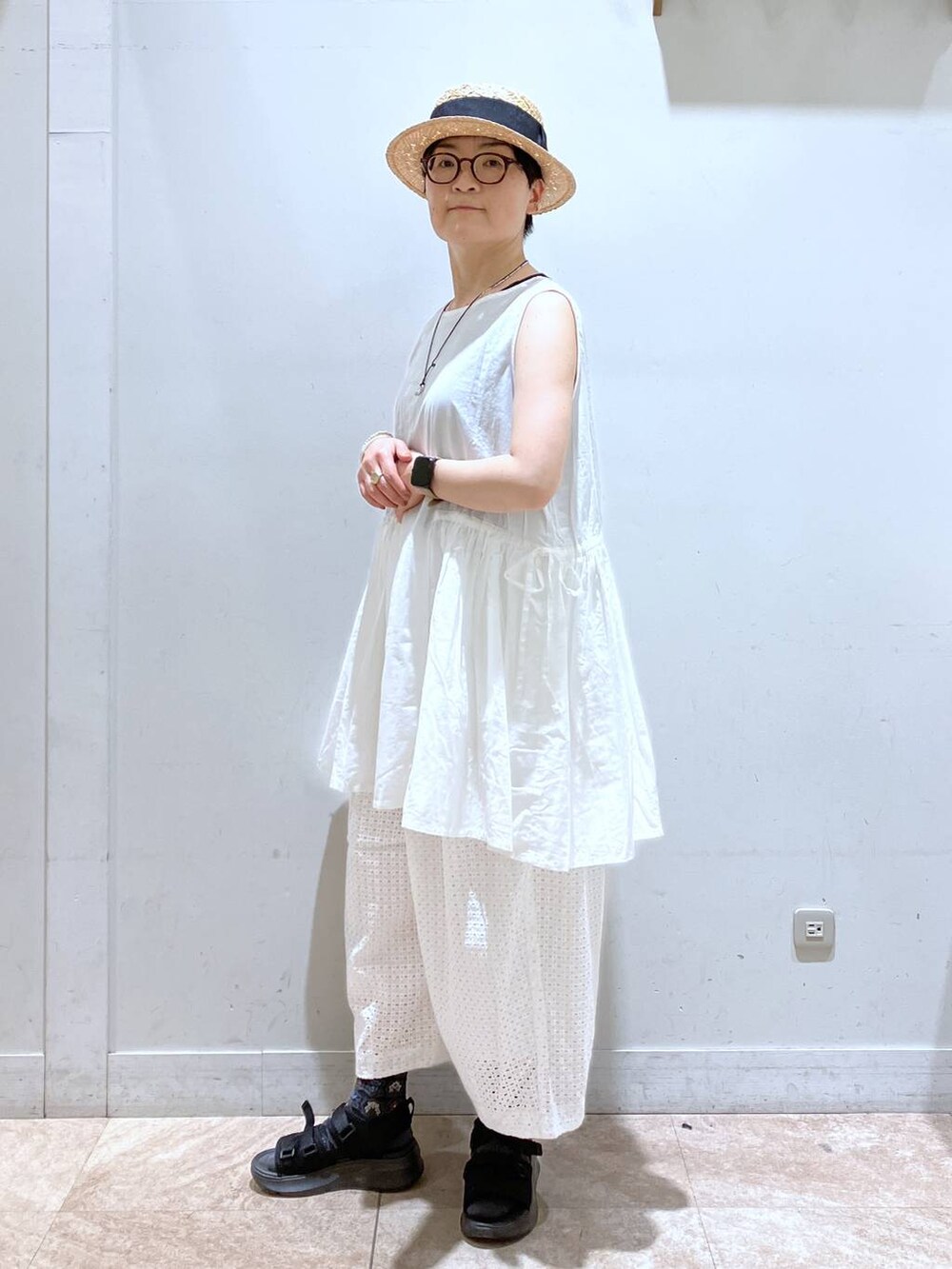 ブラック系のタンクトップ、ホワイト系のその他パンツ、その他のイヤリングを着用したレディースの春コーディネートの9枚目の写真