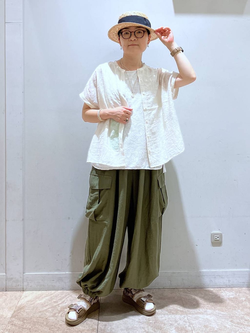 グリーン系のカーゴパンツ、その他のサンダル、ベージュ系のTシャツ/カットソーを着用したレディースの夏コーディネートの4枚目の写真
