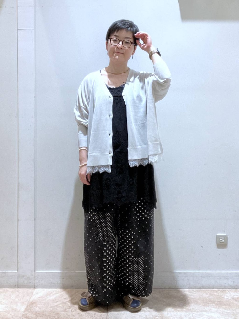 グレー系のカーディガン/ボレロ、ブラック系のチュニック、その他のサンダルを着用したレディースの夏コーディネートの2枚目の写真