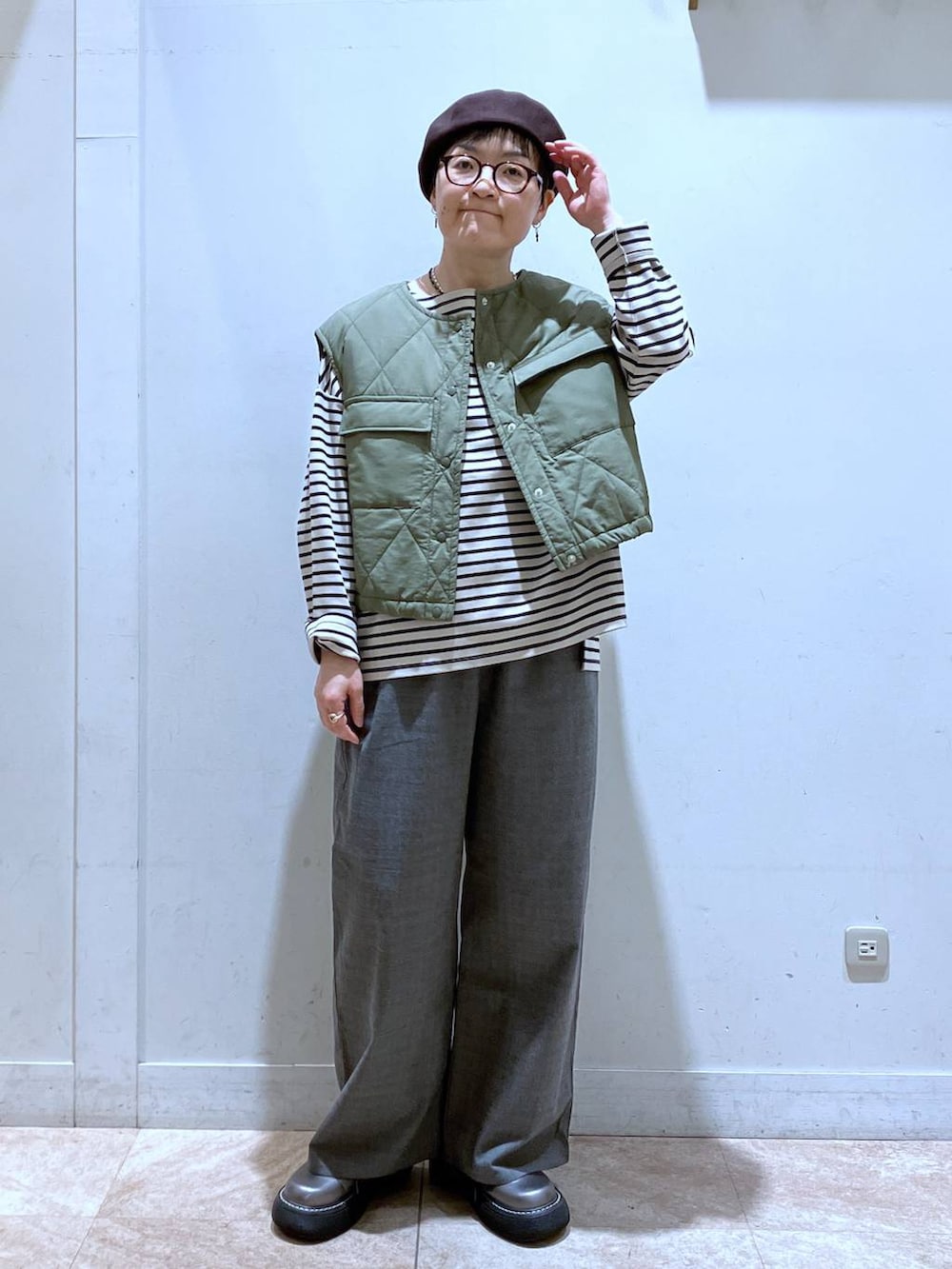 グリーン系のベスト、その他のその他シューズ、その他のTシャツ/カットソーを着用したレディースの秋コーディネートの2枚目の写真