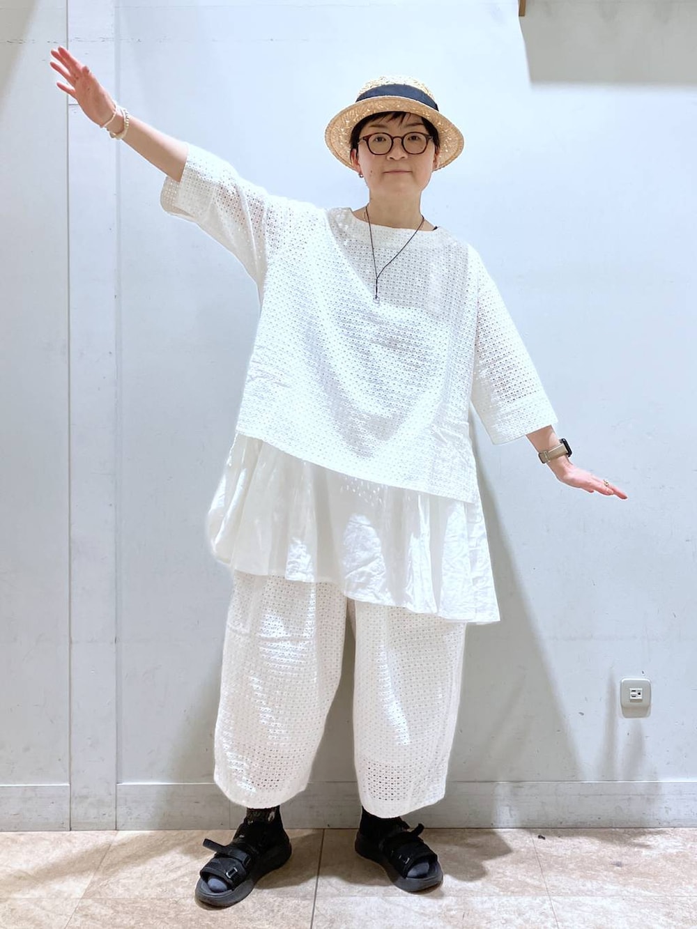 ブラック系のタンクトップ、ホワイト系のその他パンツ、その他のイヤリングを着用したレディースの春コーディネートの3枚目の写真