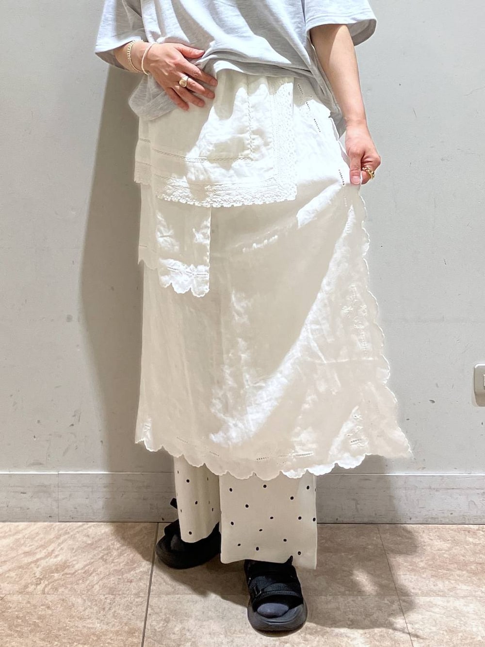 ホワイト系のスカート、グレー系のTシャツ/カットソー、シルバー系のイヤーカフを着用したレディースの春コーディネートの6枚目の写真