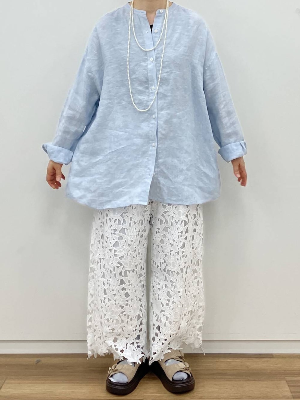 ブラック系のタンクトップ、ベージュ系のサンダル、ホワイト系のネックレスを着用したレディースの春コーディネートの5枚目の写真