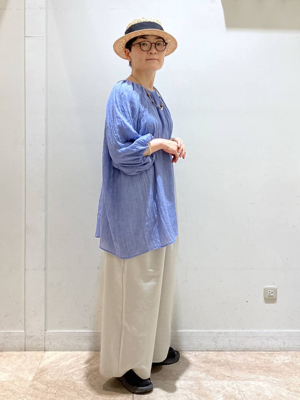 グレー系のその他パンツ、ブルー系のチュニック、シルバー系のイヤーカフを着用したレディースの夏コーディネートの3枚目の写真