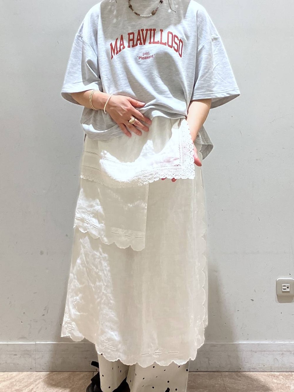 ホワイト系のスカート、グレー系のTシャツ/カットソー、シルバー系のイヤーカフを着用したレディースの春コーディネートの7枚目の写真
