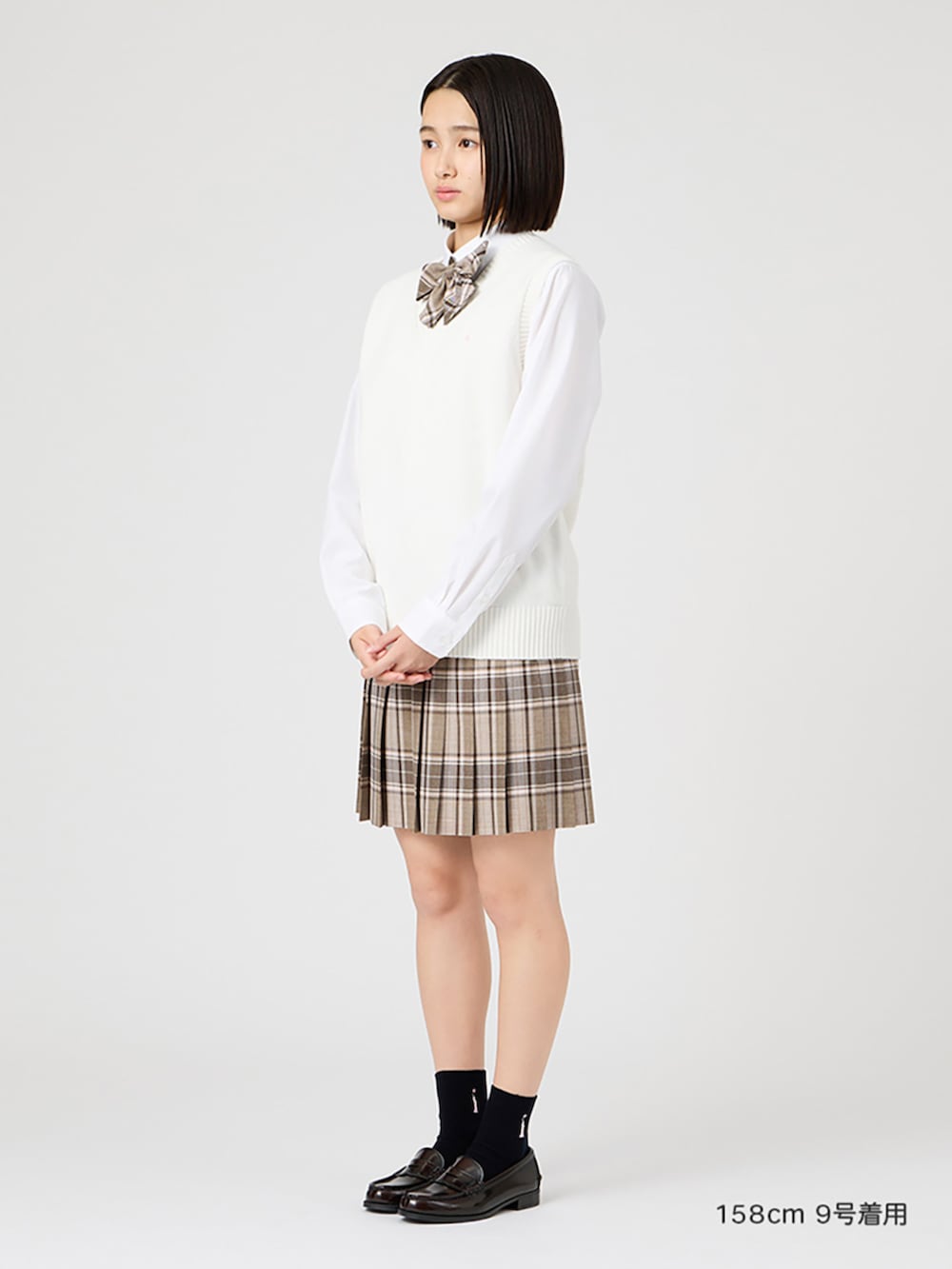 ブラウン系のローファー、ホワイト系のベスト、ホワイト系のシャツ/ブラウスを着用したレディースの冬コーディネートの2枚目の写真