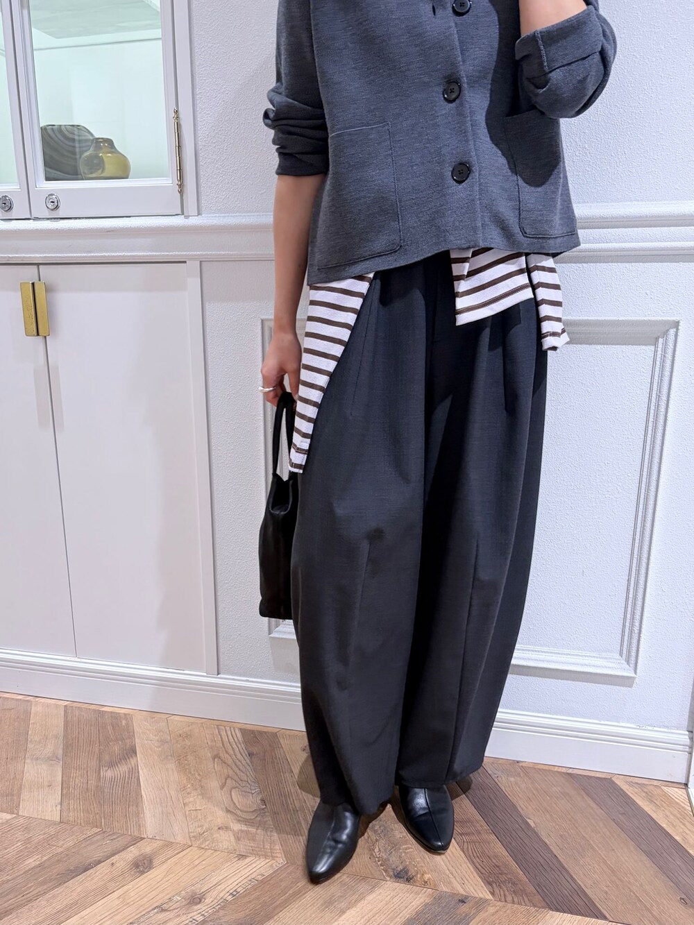 グレー系のその他パンツ、グレー系のカーディガン/ボレロ、ブラック系のブーツを着用したレディースの秋コーディネートの5枚目の写真