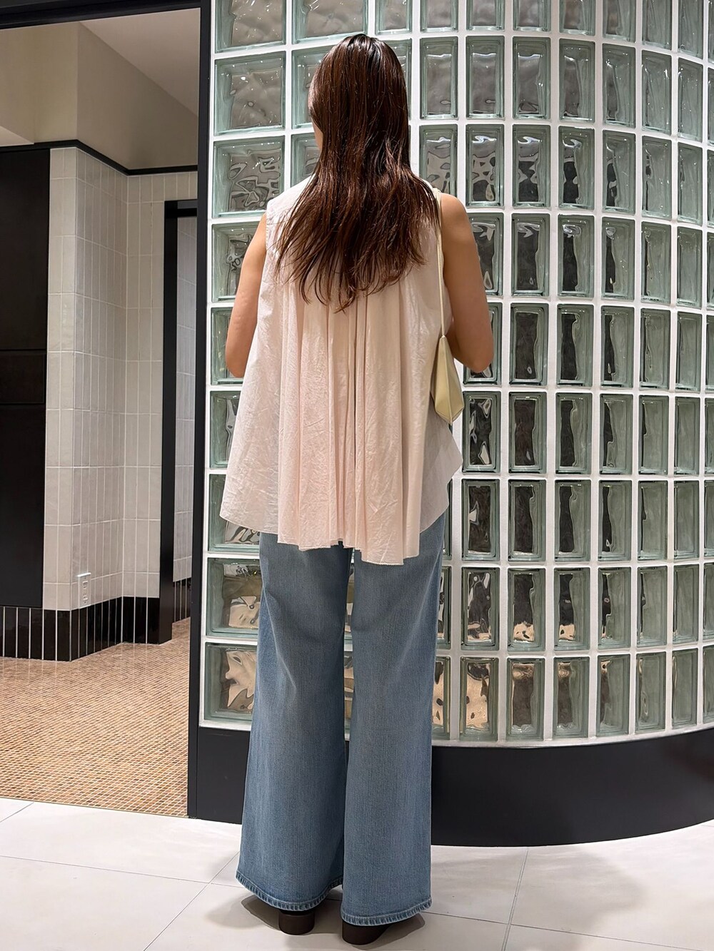 ホワイト系のショルダーバッグ、ブルー系のデニムパンツ、ピンク系のシャツ/ブラウスを着用したレディースの春コーディネートの2枚目の写真