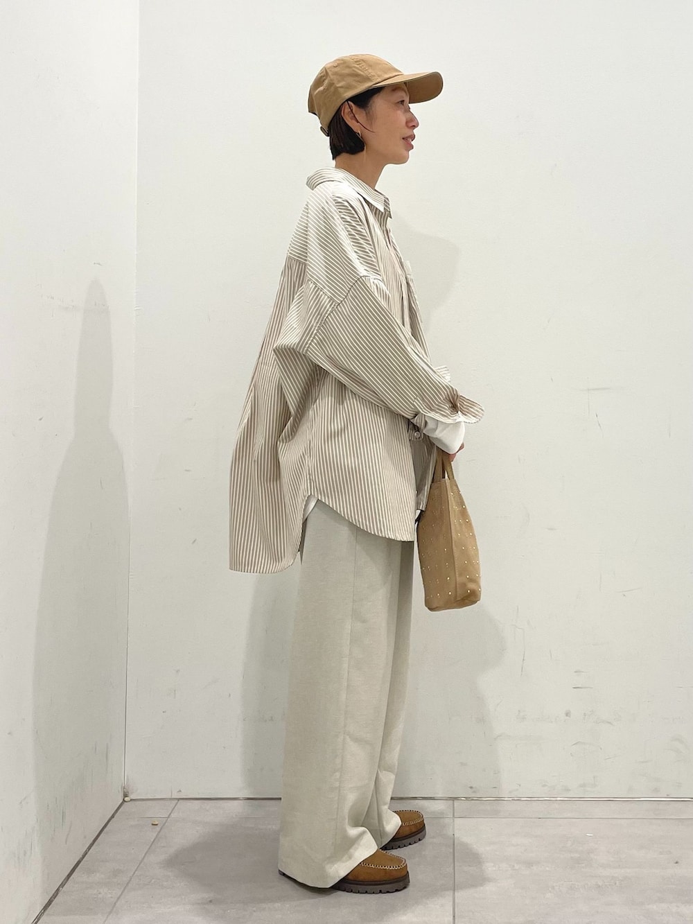 ベージュ系のその他パンツ、ベージュ系のシャツ/ブラウス、ホワイト系のTシャツ/カットソーを着用したレディースの春コーディネートの6枚目の写真