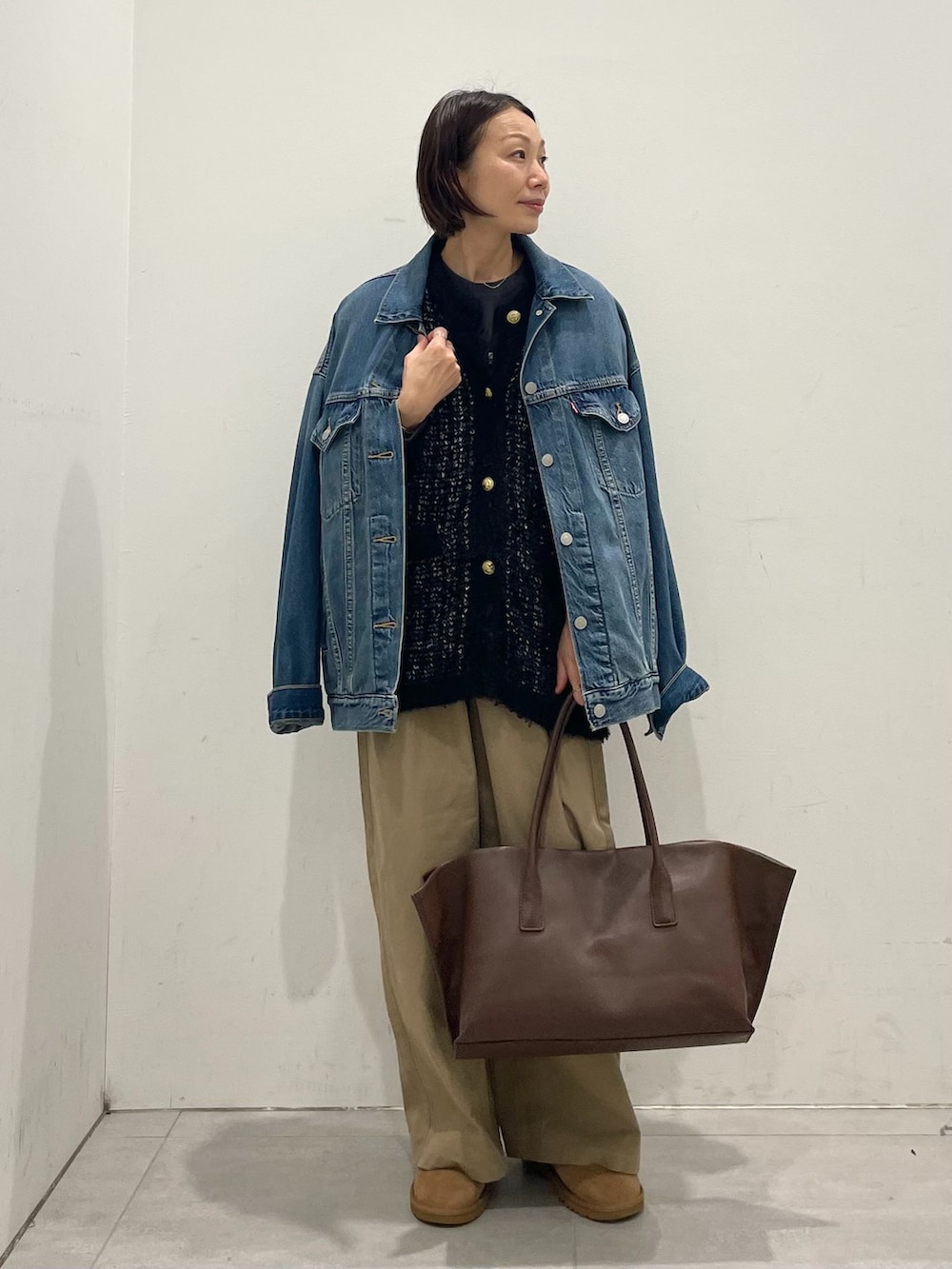 ブルー系のデニムジャケット、ベージュ系のその他パンツ、ブラック系のTシャツ/カットソーを着用したレディースの秋コーディネートの4枚目の写真
