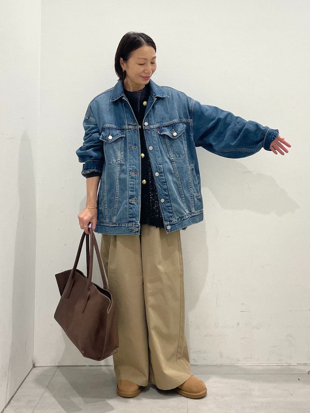 ブルー系のデニムジャケット、ベージュ系のその他パンツ、ブラック系のTシャツ/カットソーを着用したレディースの秋コーディネートの5枚目の写真