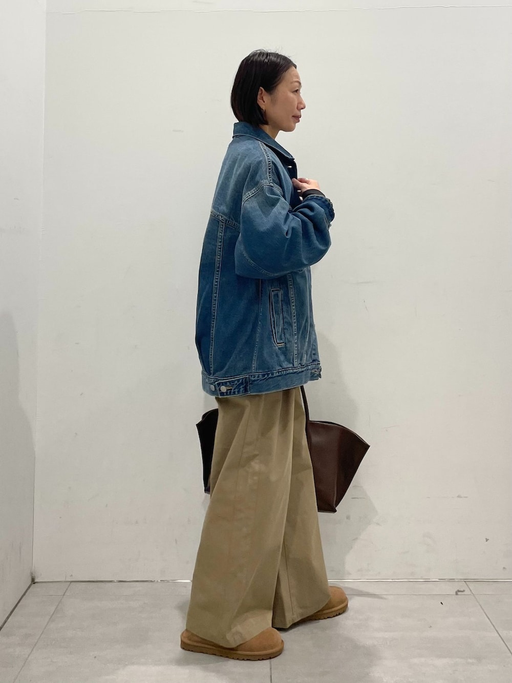 ブルー系のデニムジャケット、ベージュ系のその他パンツ、ブラック系のTシャツ/カットソーを着用したレディースの秋コーディネートの6枚目の写真
