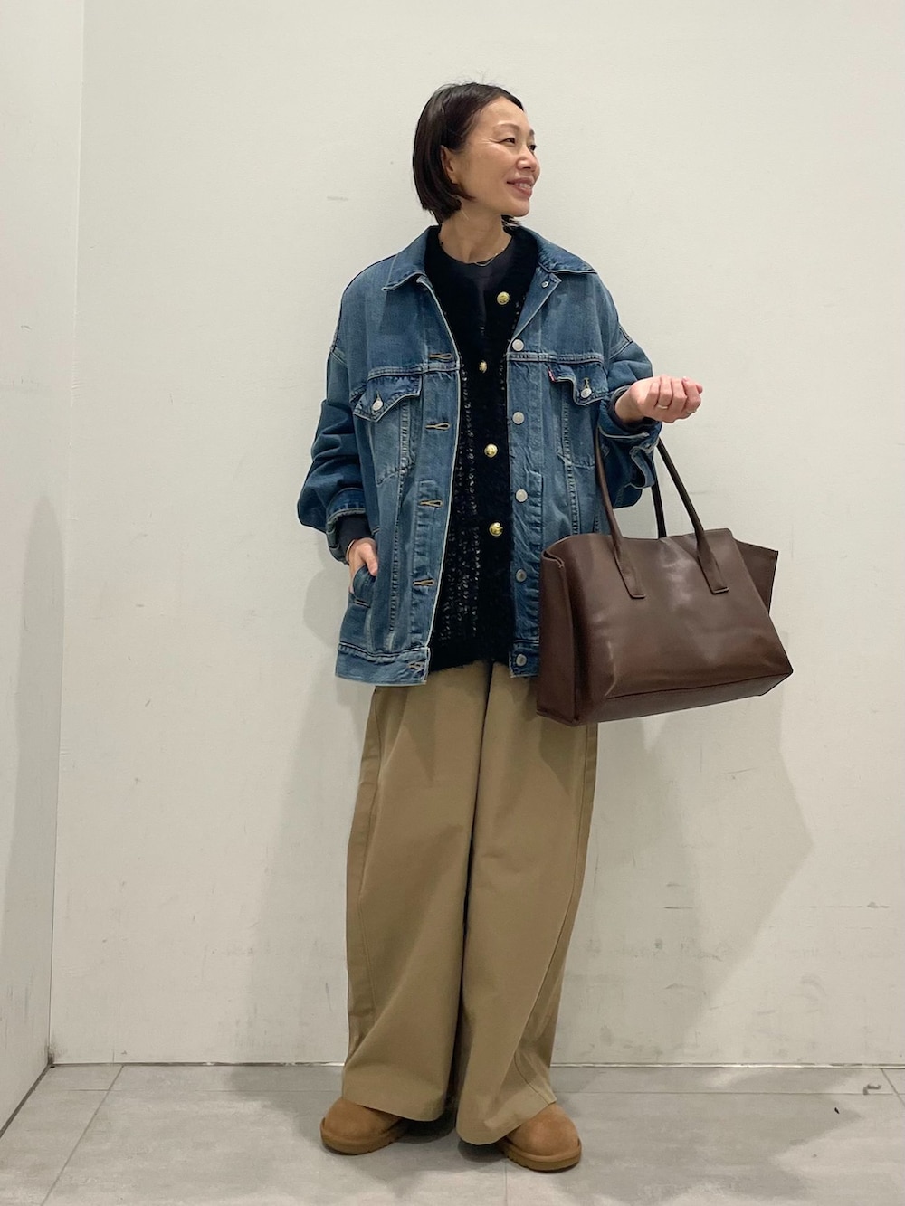 ブルー系のデニムジャケット、ベージュ系のその他パンツ、ブラック系のTシャツ/カットソーを着用したレディースの秋コーディネートの2枚目の写真