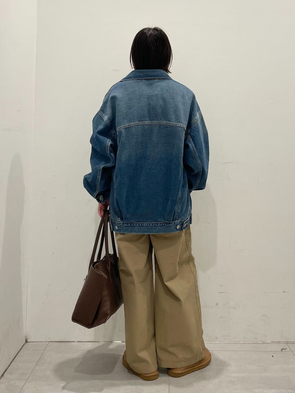 ブルー系のデニムジャケット、ベージュ系のその他パンツ、ブラック系のTシャツ/カットソーを着用したレディースの秋コーディネートの7枚目の写真