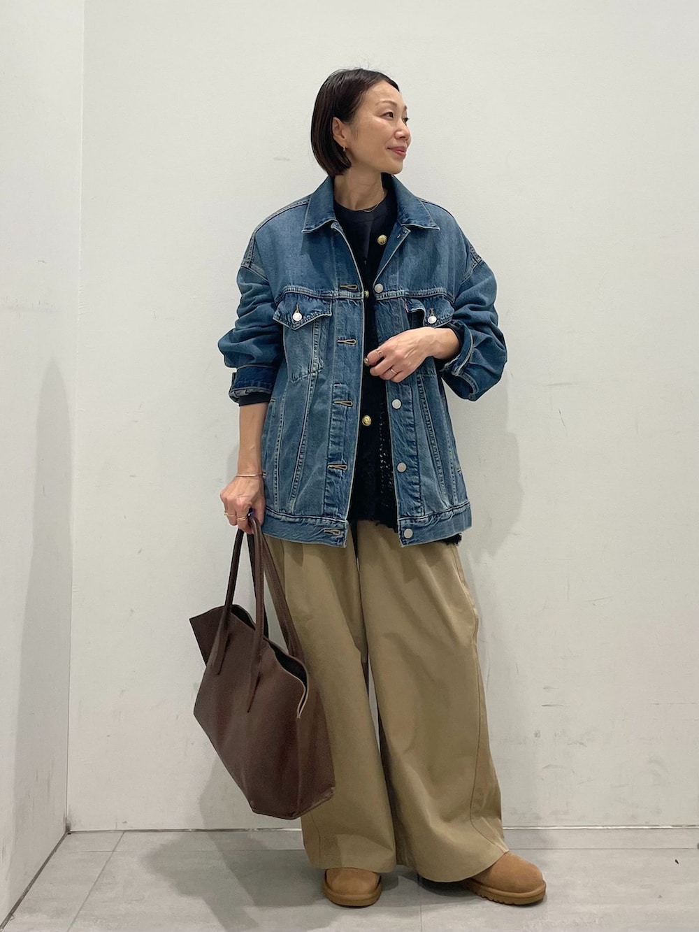 ブルー系のデニムジャケット、ベージュ系のその他パンツ、ブラック系のTシャツ/カットソーを着用したレディースの秋コーディネートの3枚目の写真