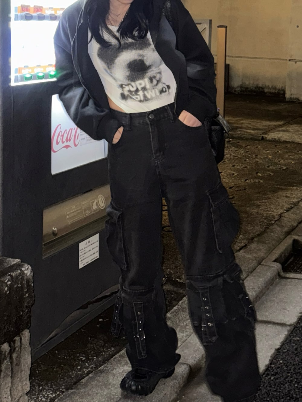 ブラック系のパーカー、ホワイト系のTシャツ/カットソー、ブラック系のカーゴパンツを着用したレディースの冬コーディネートの2枚目の写真