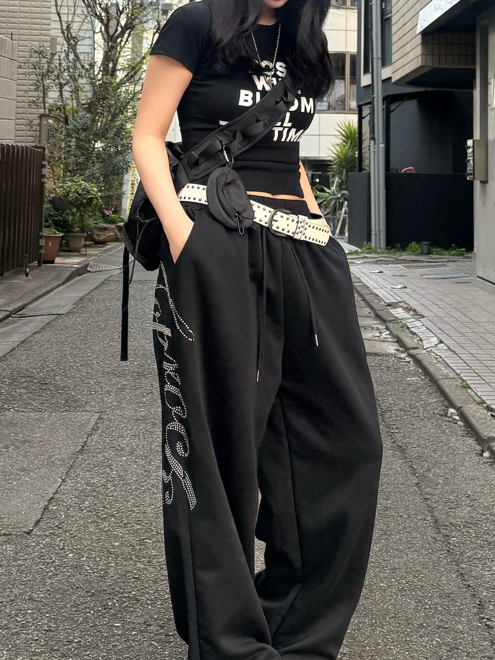 ブラック系のスウェットパンツ、ブラック系のショルダーバッグ、ブラック系のTシャツ/カットソーを着用したレディースの春コーディネートの2枚目の写真