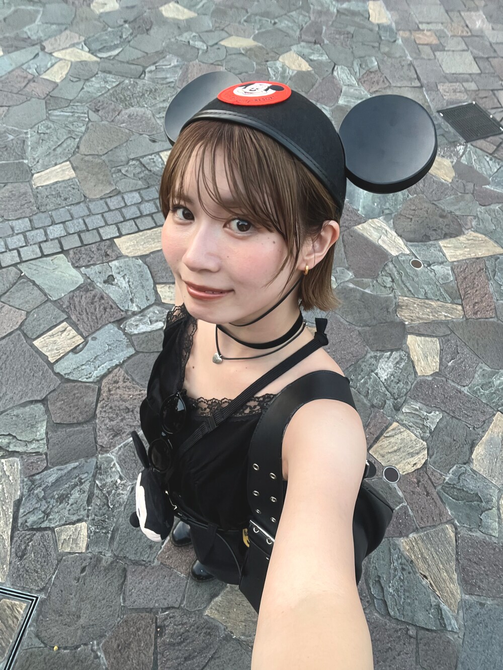ブラック系のキャミソール、ブラック系のチノパンツ、ブラック系のショルダーバッグを着用したレディースの夏コーディネートの5枚目の写真
