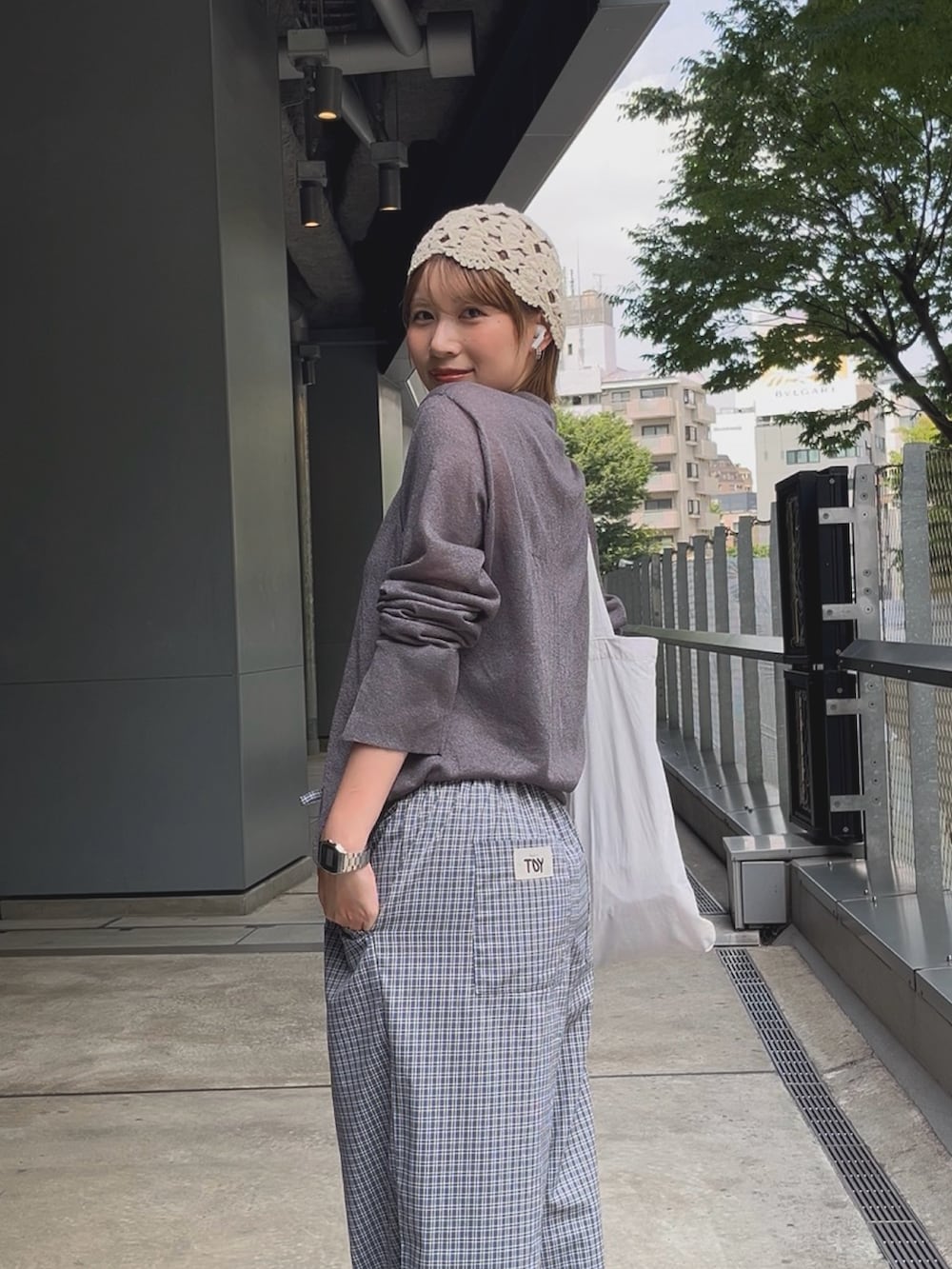 グレー系のシャツ/ブラウス、ブルー系のパンツ、ブラック系のサンダルを着用したレディースの夏コーディネートの2枚目の写真