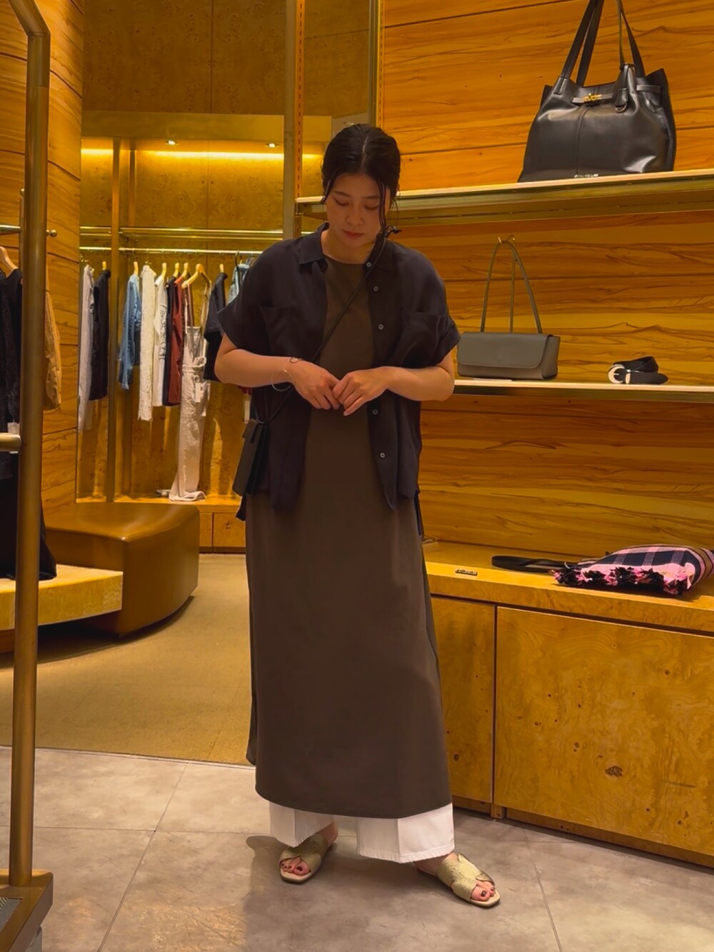 グレー系のワンピース、ホワイト系のデニムパンツ、ゴールド系のその他シューズを着用したレディースの春コーディネートの3枚目の写真