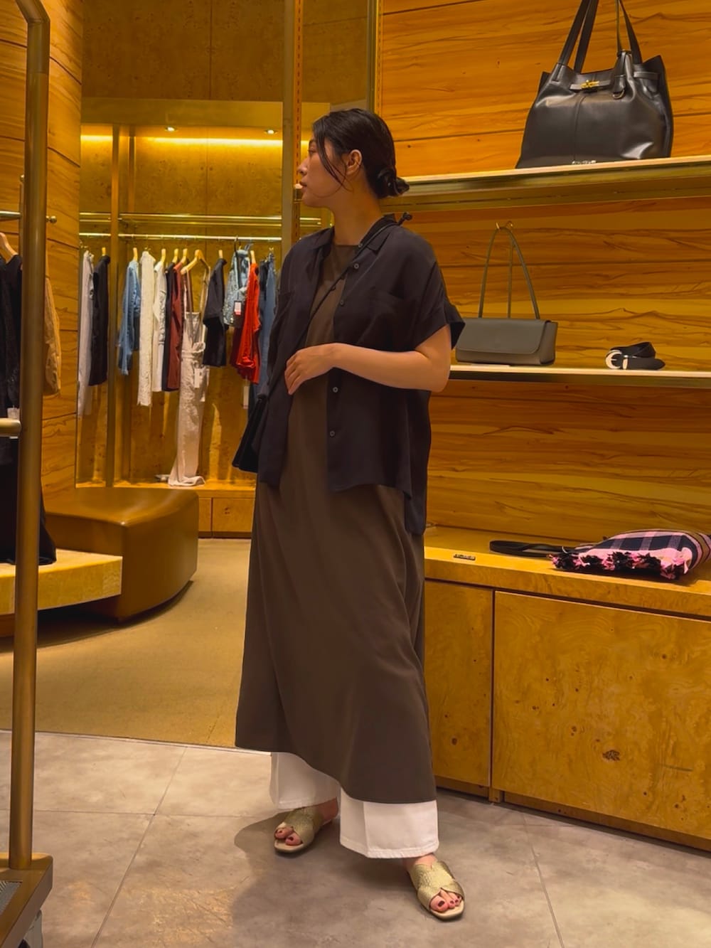 グレー系のワンピース、ホワイト系のデニムパンツ、ゴールド系のその他シューズを着用したレディースの春コーディネートの4枚目の写真