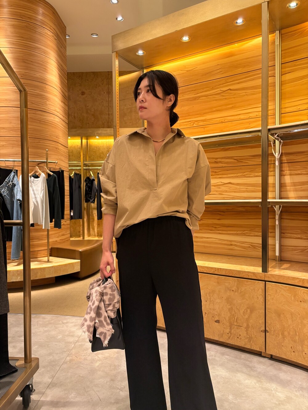 ベージュ系のシャツ/ブラウス、ブラック系のその他パンツ、ブラック系のボストンバッグを着用したレディースの秋コーディネートの3枚目の写真