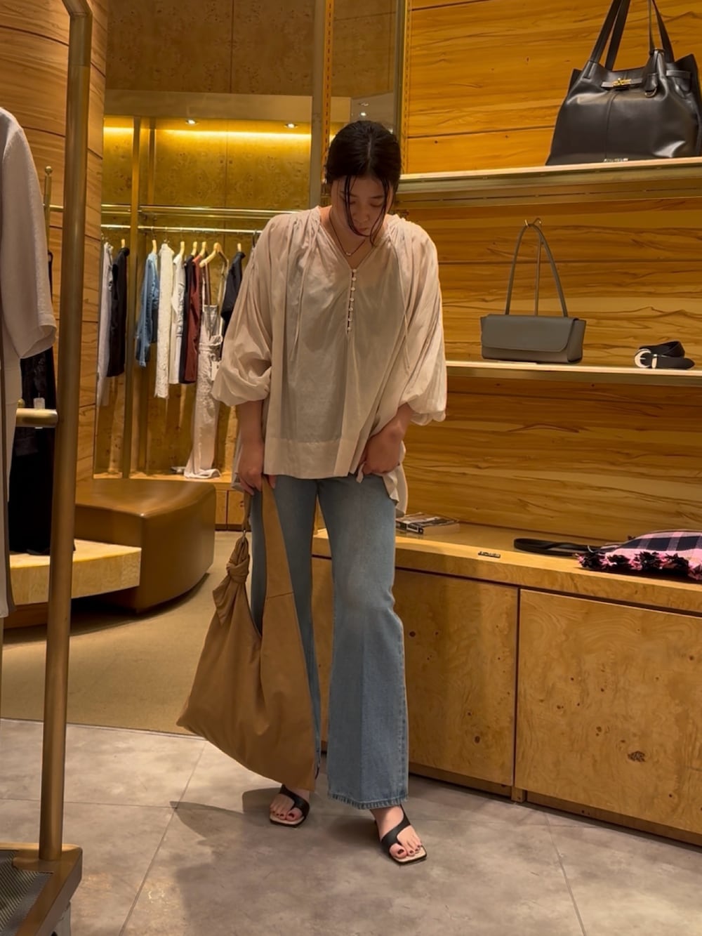 ベージュ系のシャツ/ブラウス、ブルー系のデニムパンツ、イエロー系のトートバッグを着用したレディースの夏コーディネートの2枚目の写真