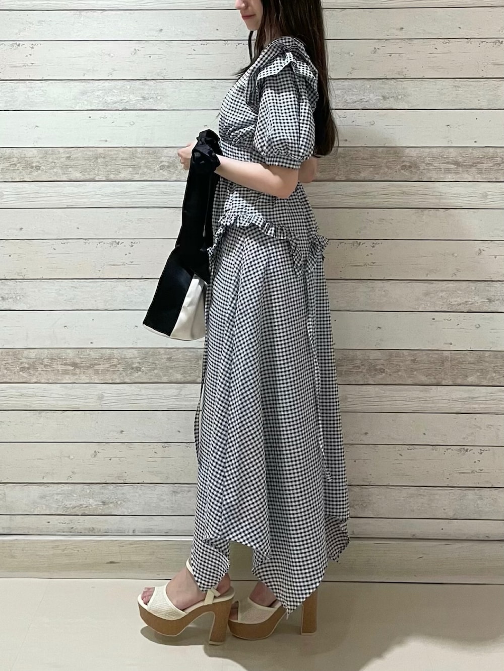 その他のワンピース、ホワイト系のハンドバッグ、ホワイト系のサンダルを着用したレディースの夏コーディネートの2枚目の写真