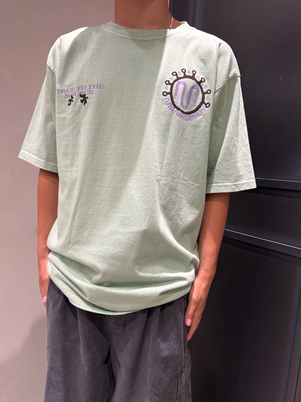 グリーン系のTシャツ/カットソー、グレー系のカーゴパンツ、ブラック系のサンダルを着用したメンズの夏コーディネートの2枚目の写真