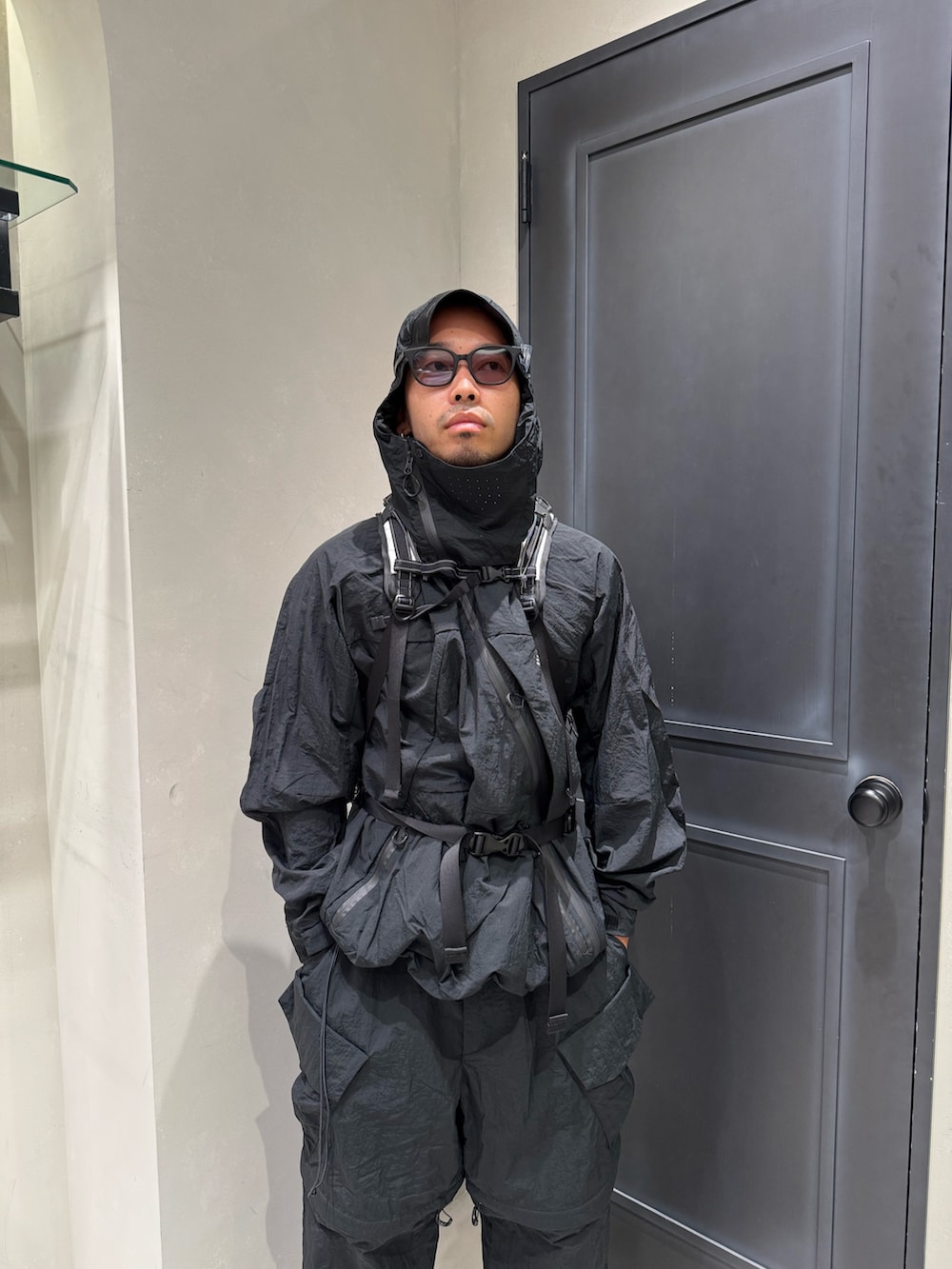 ブラック系のマウンテンパーカー、ブラック系のカーゴパンツ、ブラック系のサンダルを着用したメンズの秋コーディネートの2枚目の写真