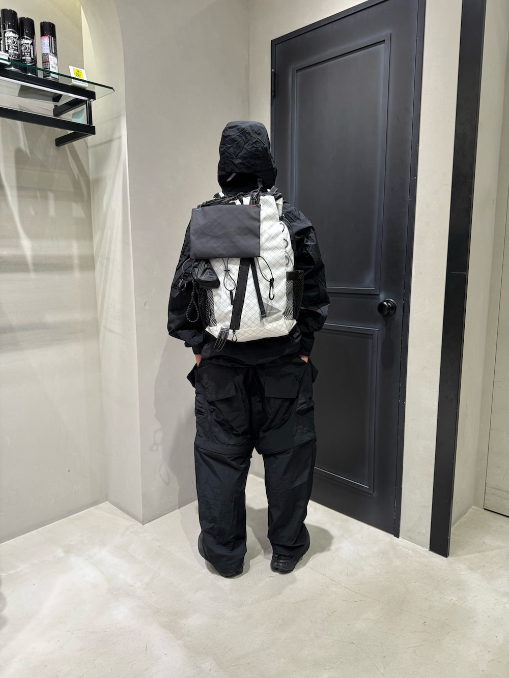 ブラック系のマウンテンパーカー、ブラック系のカーゴパンツ、ブラック系のサンダルを着用したメンズの秋コーディネートの4枚目の写真
